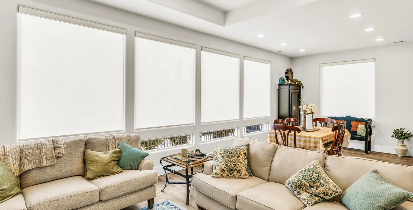 white roller shades in a large living room area with tall windows