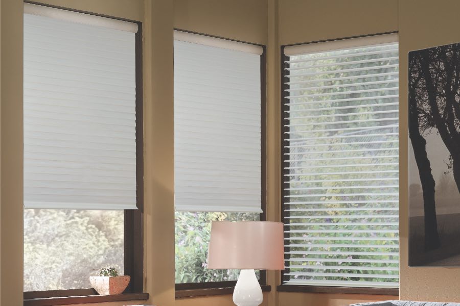 Opaque motorized window shades in Riverside keep hot UV rays out of your home. Gray motorized sheer shades on corner windows next to gray furniture