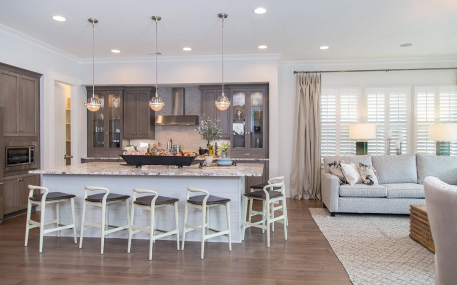 Illuminate your home with custom interior shutters in Riverside. White arched shutters in a white kitchen with lots of light.