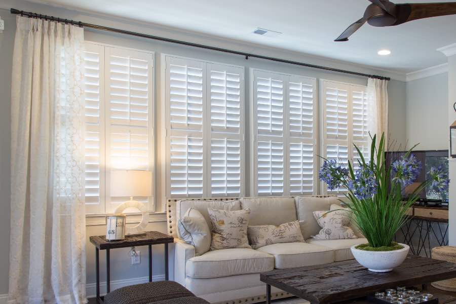 No matter how you decorate your great room, Polywood shutters will fit right in! White Polywood shutters on windows behind a white sofa