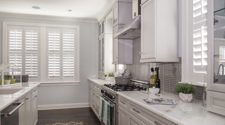 Plantation shutters in Riverside kitchen with white cabinets.