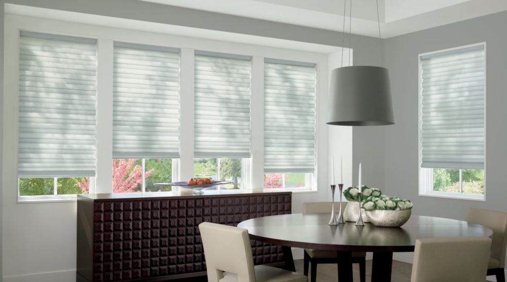 Custom cordless roller shades have a clean look and are appropriate for any room. Cordless motorized shades in a Riverside dining room