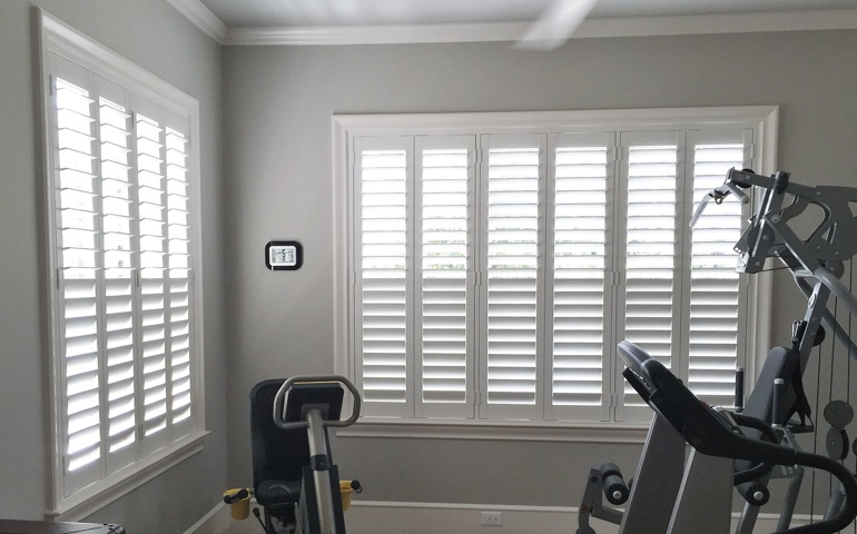 Riverside home gym with shuttered windows.