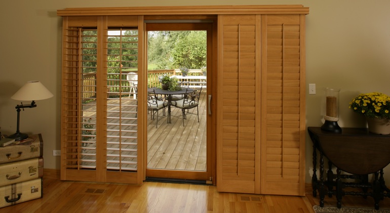 Wood shutters create a buffer that transitions from indoor wood to patio. Riverside wood shutter sliding door