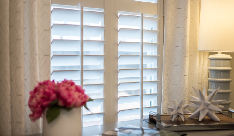 Plantation shutters by flowers in Riverside