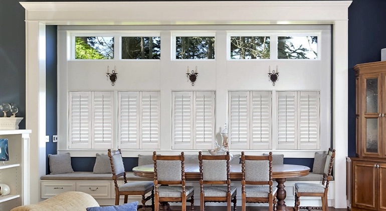 Riverside dining room with shut plantation shutters.