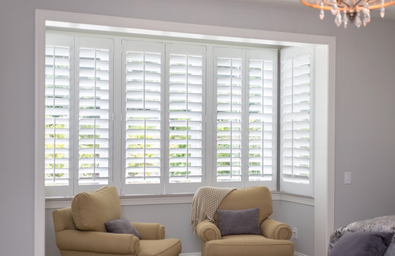 North-South windows have energy efficiency problems instead of sun glare issues. White plantation shutters in sitting area