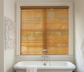 Blinds light faux wood blinds above a modern bathtub