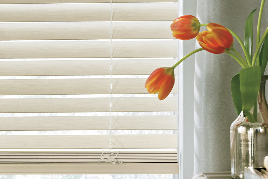 Elegant window blinds add character and texture to your living space. White wood blinds up close in a living space