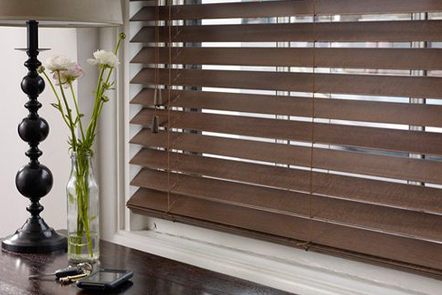 Polywood faux wood blinds blend well with any type of interior design. Dark faux wood blinds in a living room.