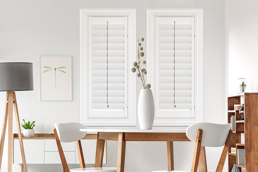 Sunburst's selection of stylish window treatments for designers in Riverside makes it easy to find the perfect ones for every design job.  White Polywood shutters on two windows in a modern Scandinavian-style room