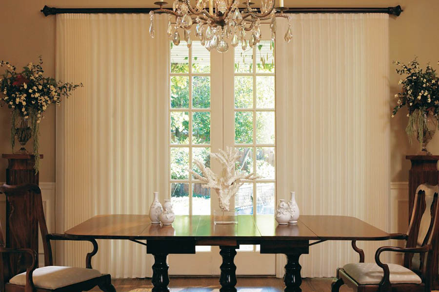 Luxurious drapes look elegant in formal rooms. White drapes on French doors in a formal dining room