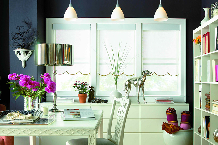Sleek roller shades bring sunlight and style to a dark room. White roller shades with scalloped edge in a colorful dining room.