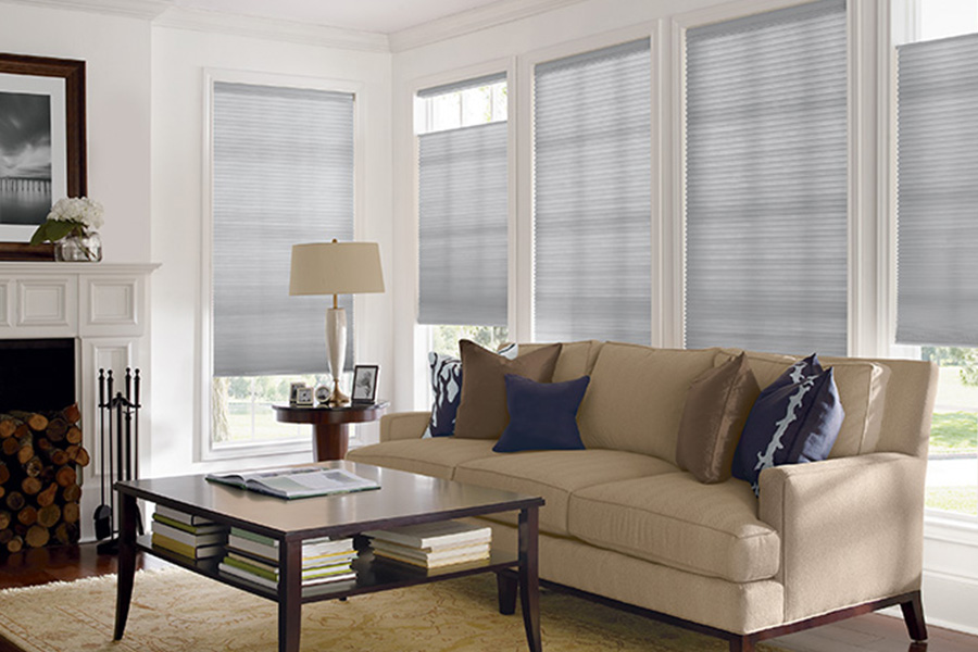 Premium window blinds are cost-effective and stylish for your window treatments. Gray window blinds on windows in a neutral living room