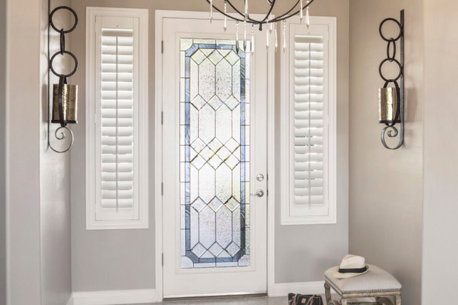 Polywood shutters offer flexibility on the brightness of natural light in Riverside. Sidelight windows with white polywood shutters in a foyer.