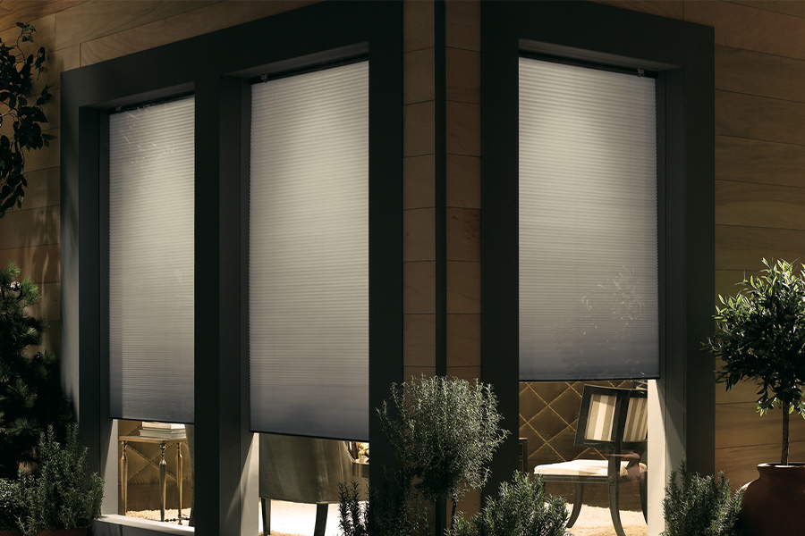 Cellular shades are modern and stylish window treatments for your home in Riverside. Dark gray cellular shades displayed from the exterior of a home.
