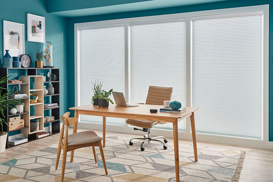 Find the perfect light level for your home office with adjustable window treatments. White sheer shades on big windows in a teal home office